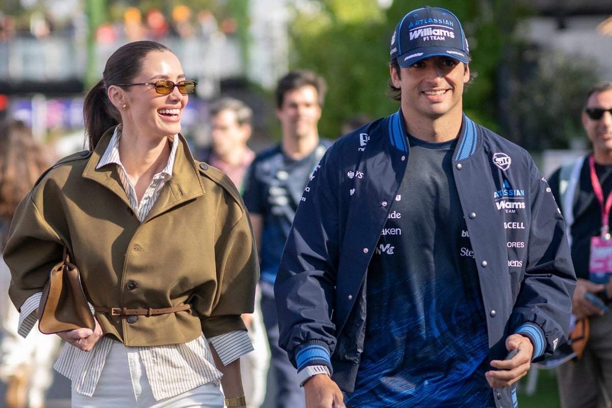 Rebecca Donaldson laughing walking next to partner Carlos Sainz in the F1 paddock