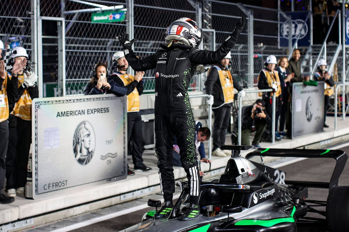 Doriane Pin stood on F1 Academy car with helmet and race suit on in Las Vegas GP pit lane after winning championship