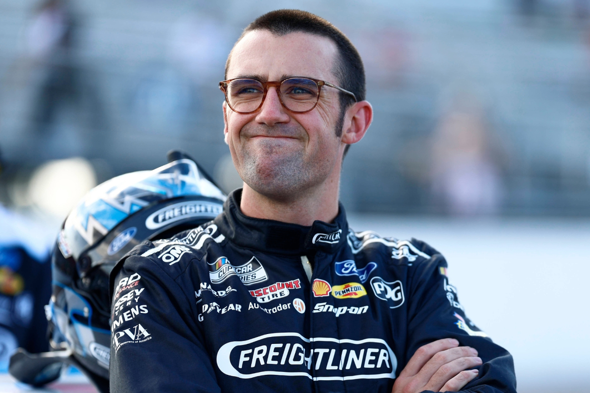 An image of Team Penske NASCAR star Austin Cindric standings with his arms crossed