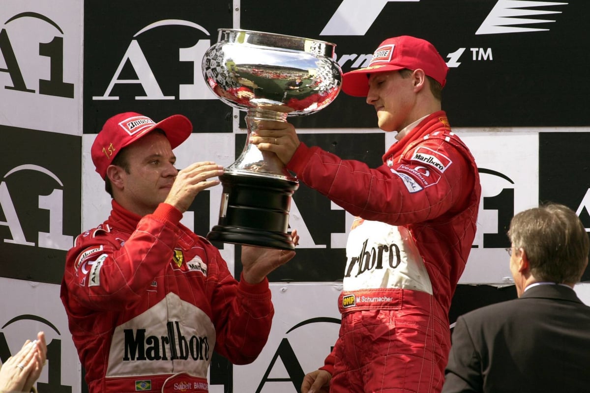 Michael Schumacher gives the winner's trophy to Rubens Barrichello at the 2002 Austrian Grand Prix