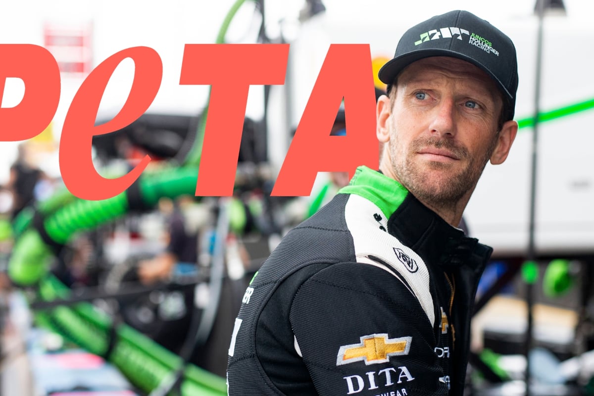 Romain Grosjean in front of the PETA logo
