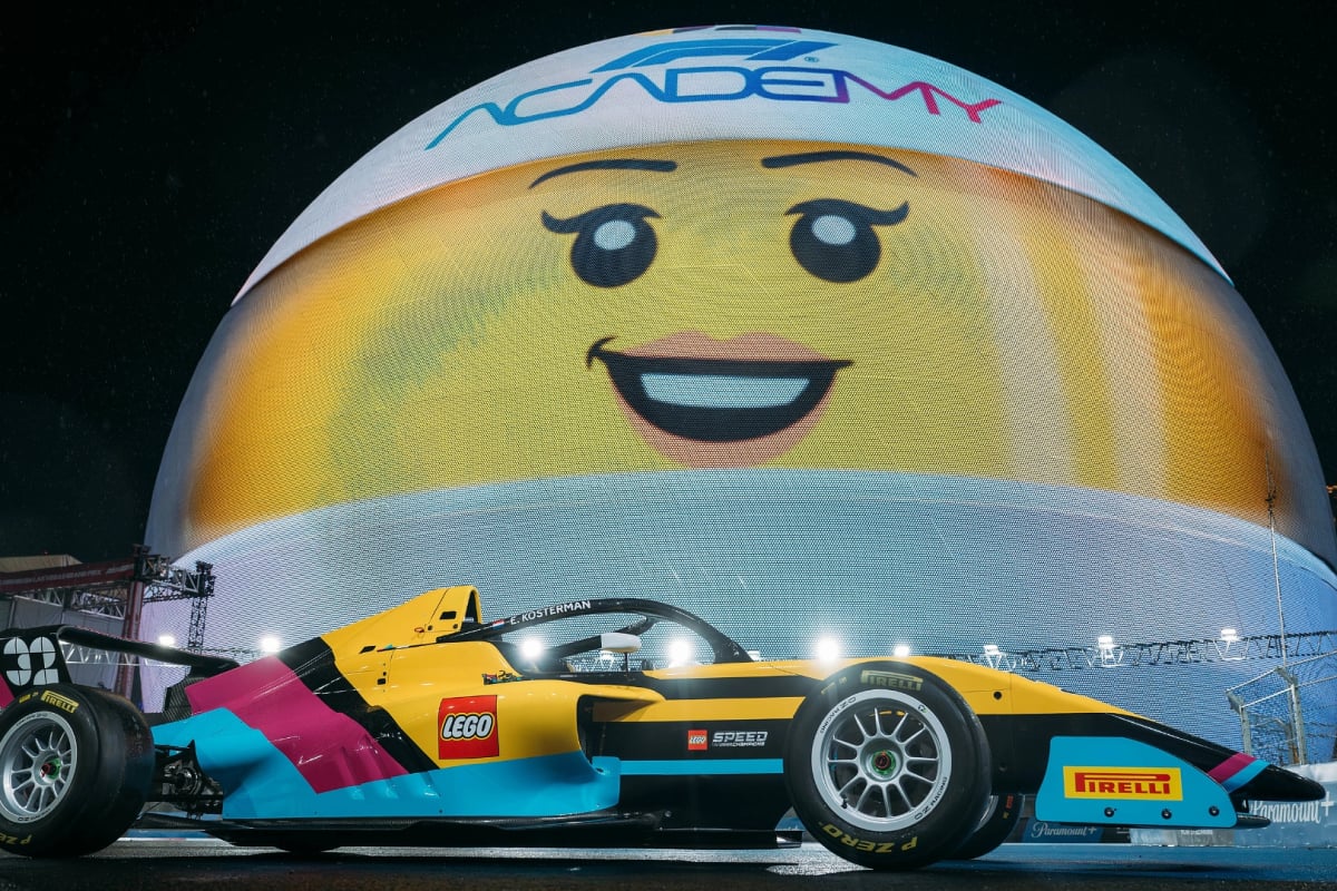 The 2026 LEGO F1 Academy car posed in front of a smiling lego face sphere