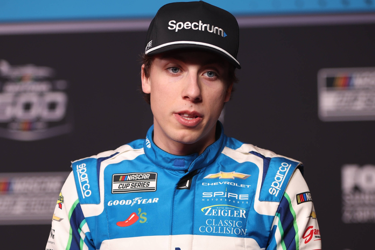 An image of Spire Motorsports driver Carson Hocevar speaking to the media at a NASCAR race