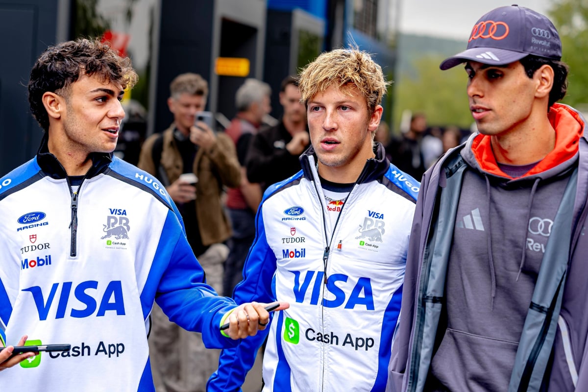 Lindblad, Lawson and Bortoleto in respective team kit in conversation walking through paddock