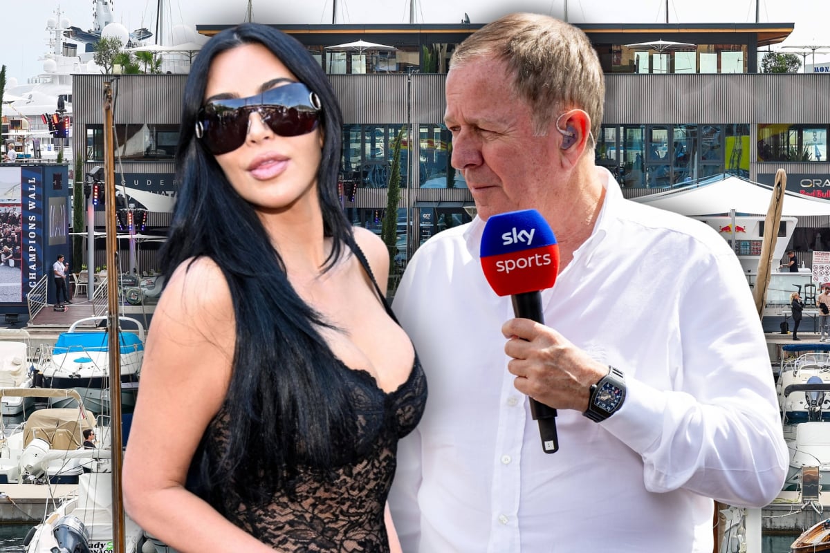 Kardashian in sunglasses edited looking away from Brundle who is holding Sky Sports mic with Monaco GP motorhome and harbour background