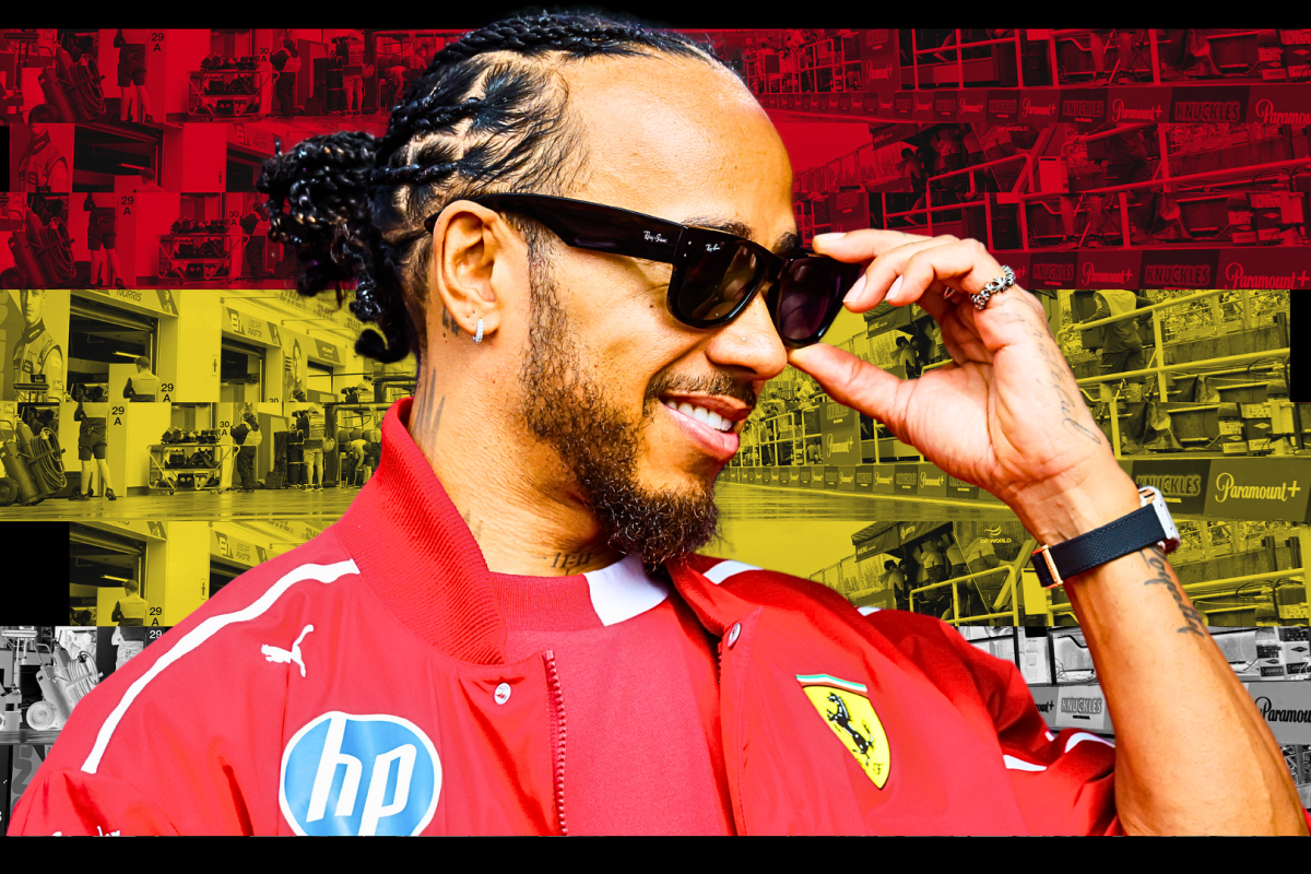 Lewis Hamilton smiling in Ferrari kit with a Belgian-themed background