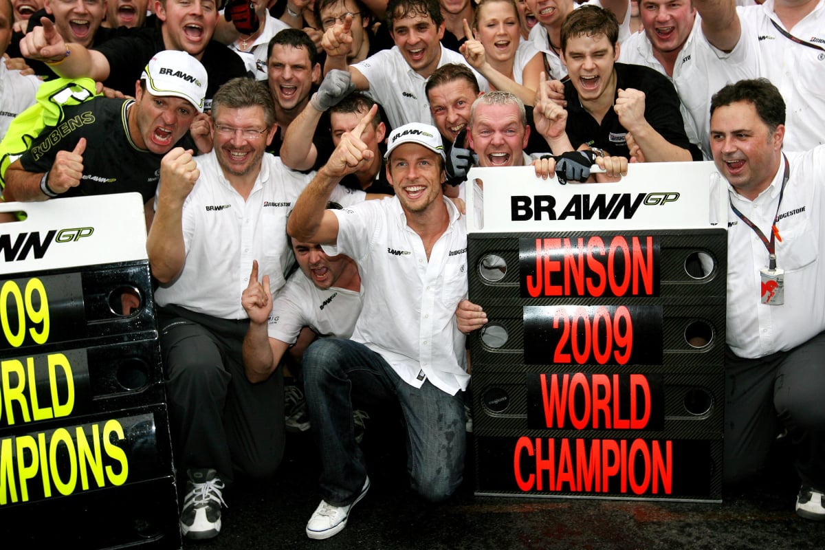 Jenson Button celebrates with Brawn staff in the Brazilian GP pitlane after becoming world champion