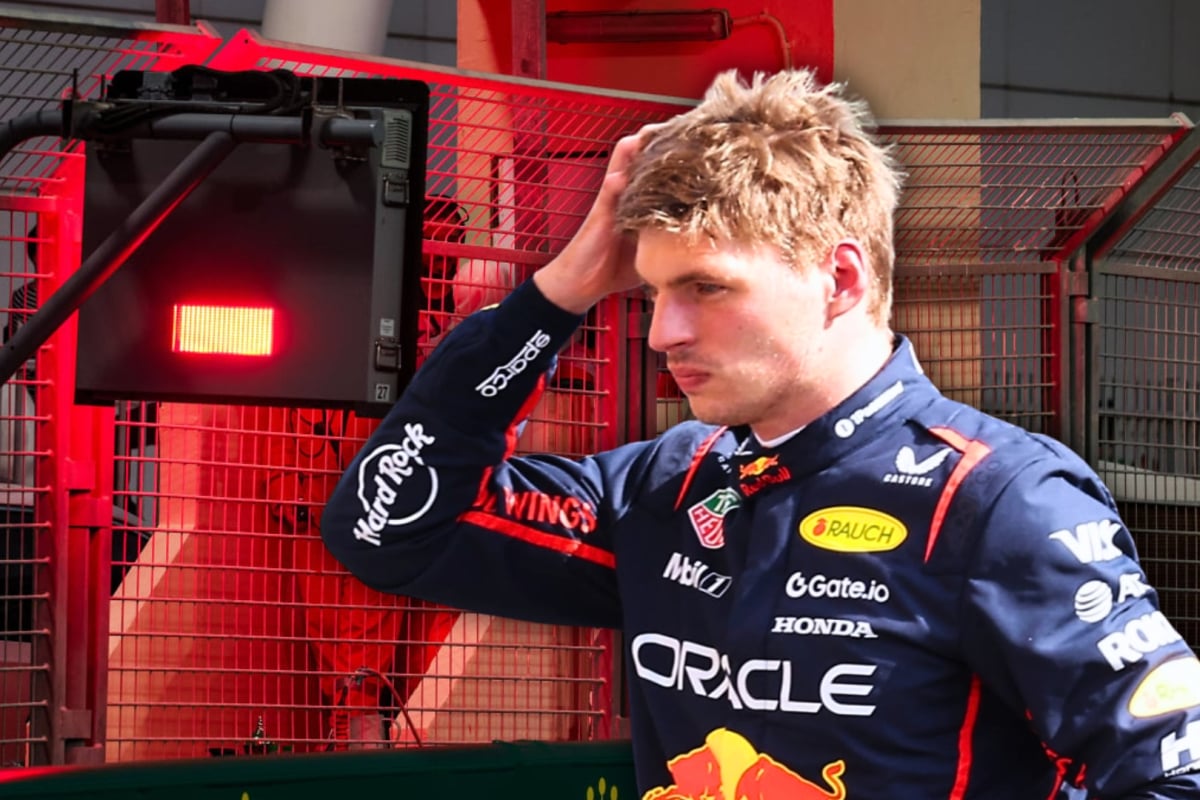 Verstappen with hand on his head looking concerned edited in front of red flag light