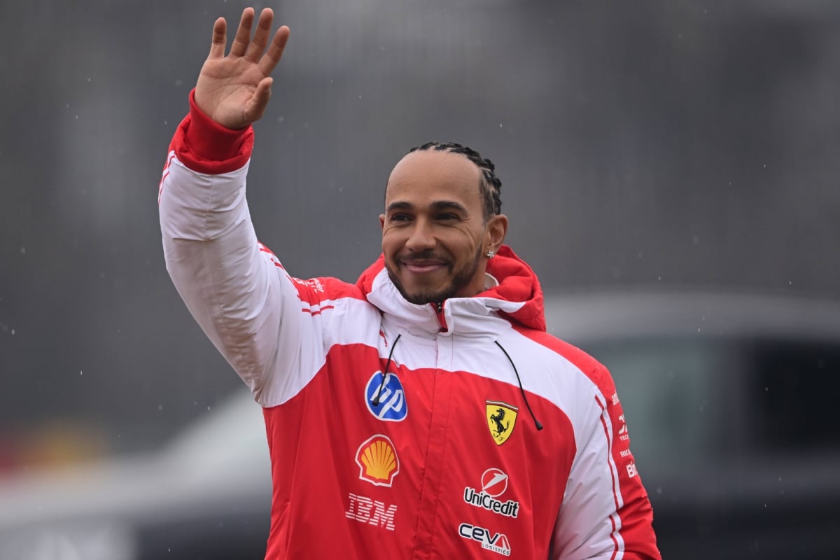 Hamilton in new Ferrari red and white F1 jacket waving at Fiorano
