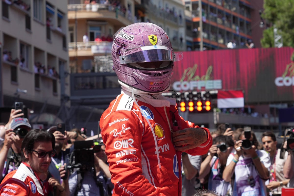 Hamilton with pink F1 helmet on in Ferrari race suit on Monaco GP grid