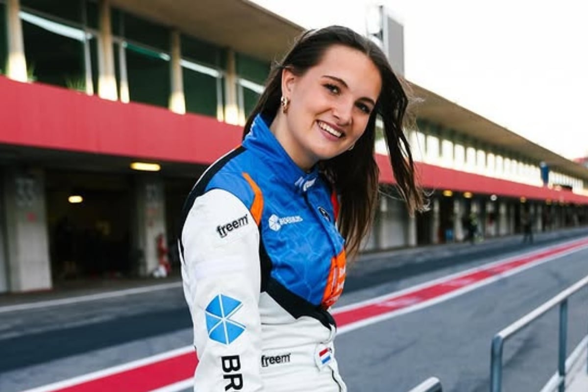 Esmee Kosterman poses for a photo trackside in a racing suit