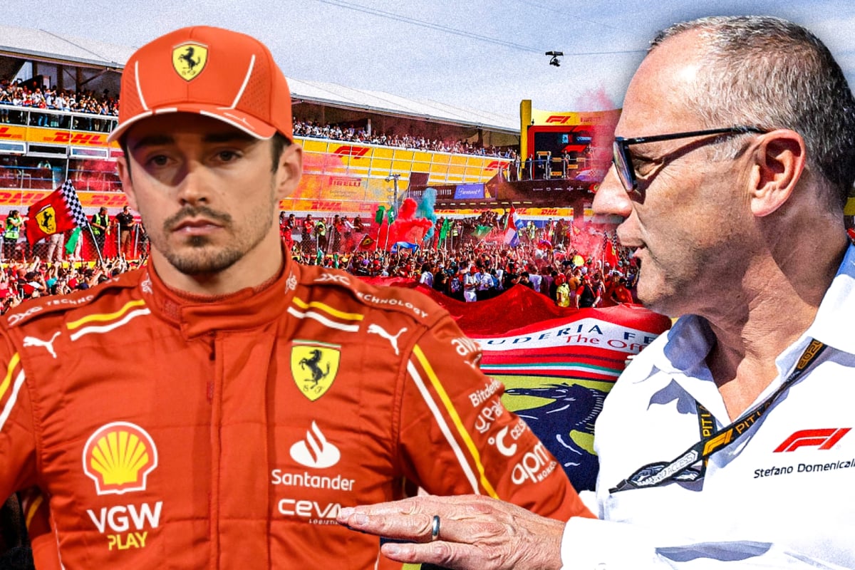 Stefano Domenicali and Charles Leclerc look at one another in front of a Ferrari background