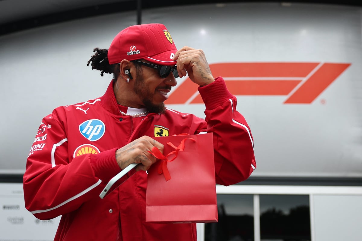Lewis Hamilton holds onto his hat in the paddock at Baku