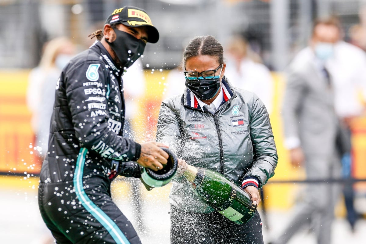 Lewis Hamilton and Stephanie Travers celebrating on the podium at the 2020 Grand Prix of Styria