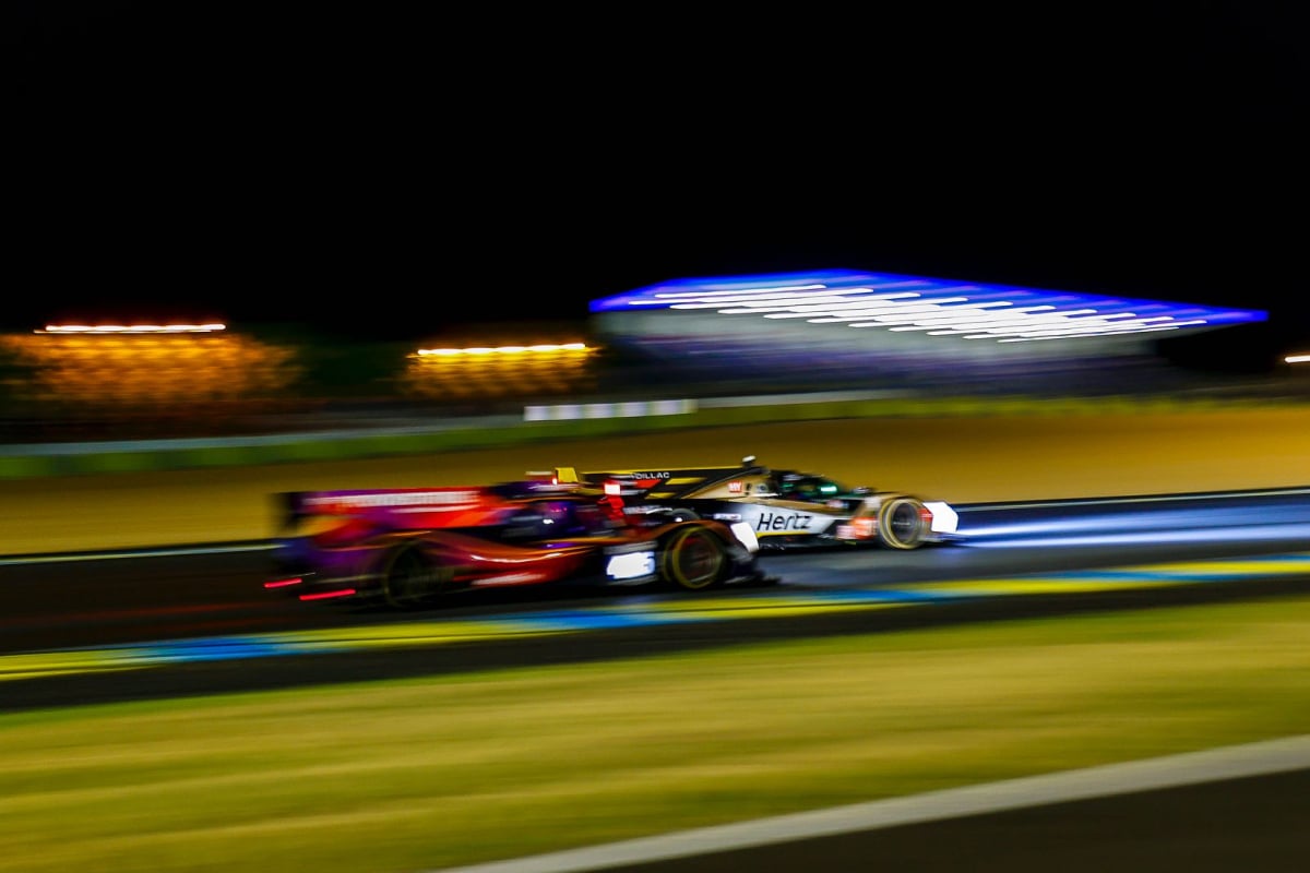 Two cars battle for position at the Le Mans 24 hour race