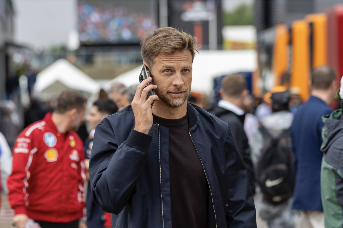Jenson Button takes a phone call while walking in the paddock at Silverstone