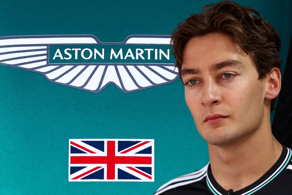 George Russell in front of an Aston Martin logo