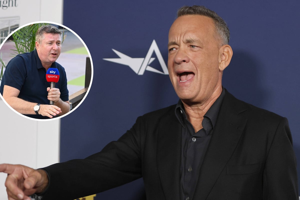 Tom Hanks looks stunned as he points to an inset photo of Sky F1 commentator David Croft