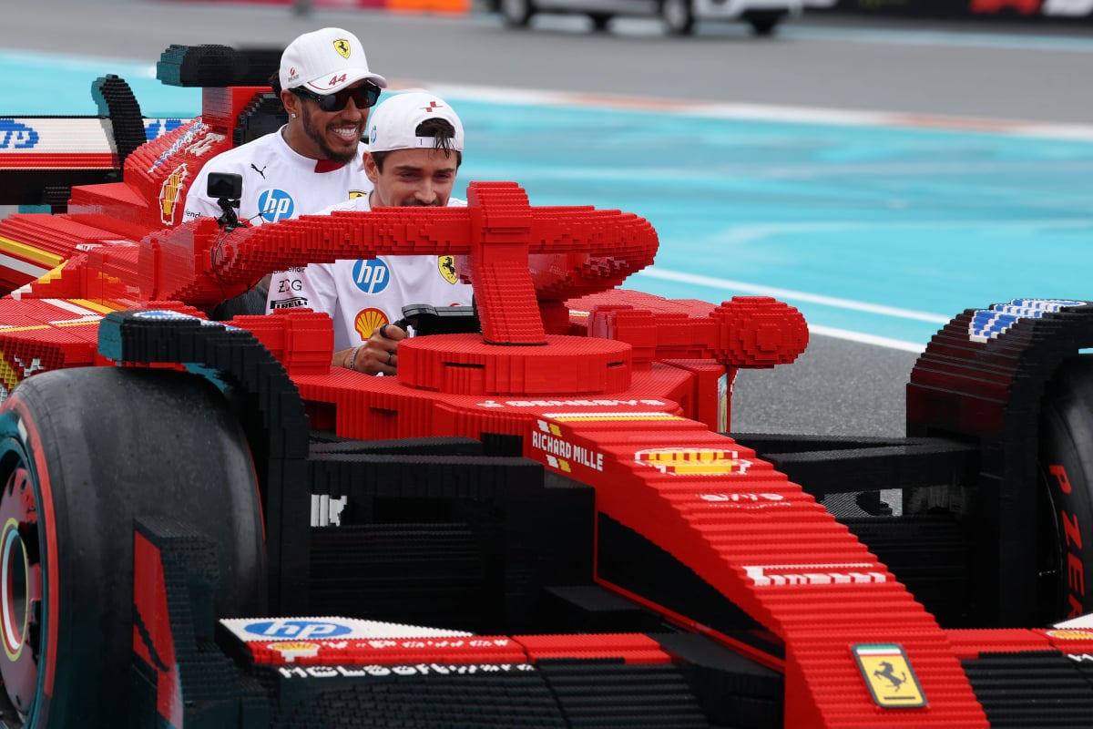Lewis Hamilton and Charles Leclerc laugh as they drive a Ferrari Lego F1 car