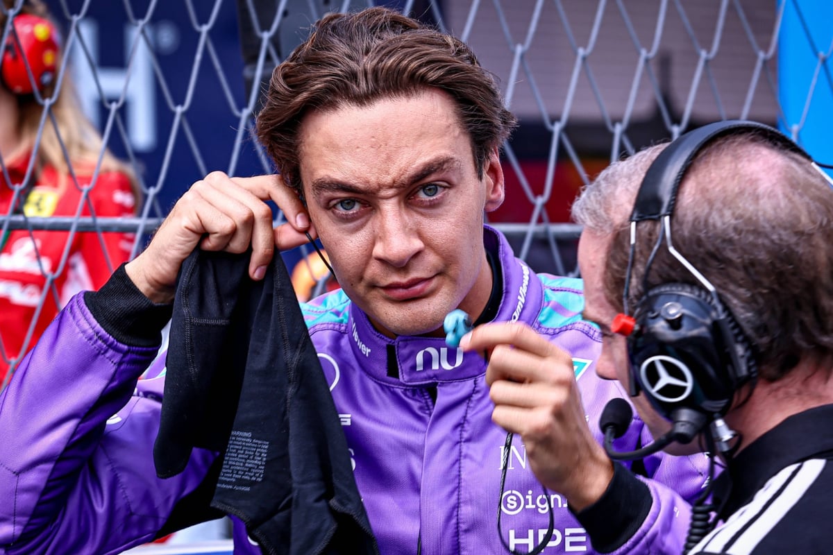 Russell screwing up his face on the F1 grid at Miami in bright purple race suit 