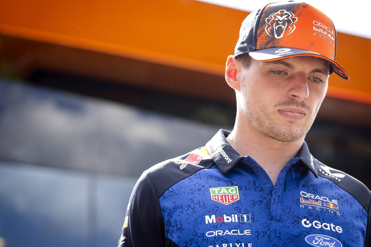 Verstappen in orange cap and navy Red Bull top looking serious at Austrian GP