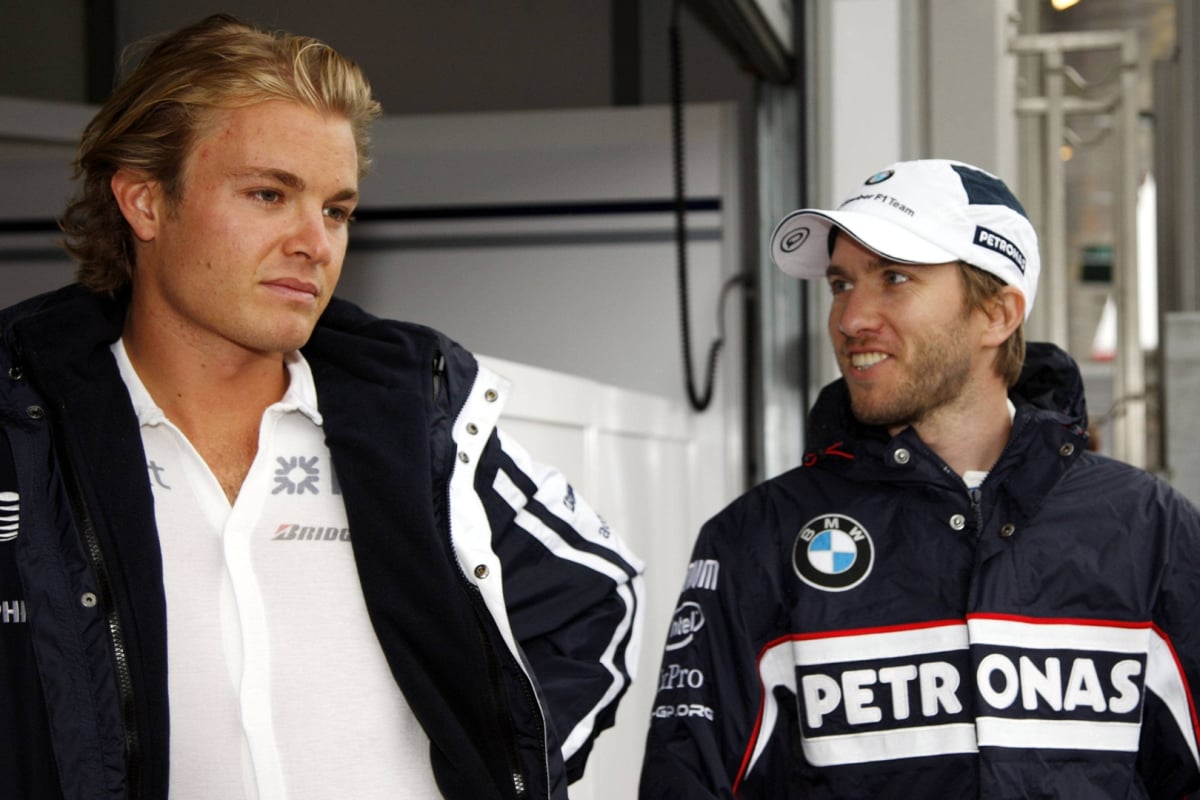 Heidfeld smiling and looking inspired by Rosberg in 2009 at an F1 track