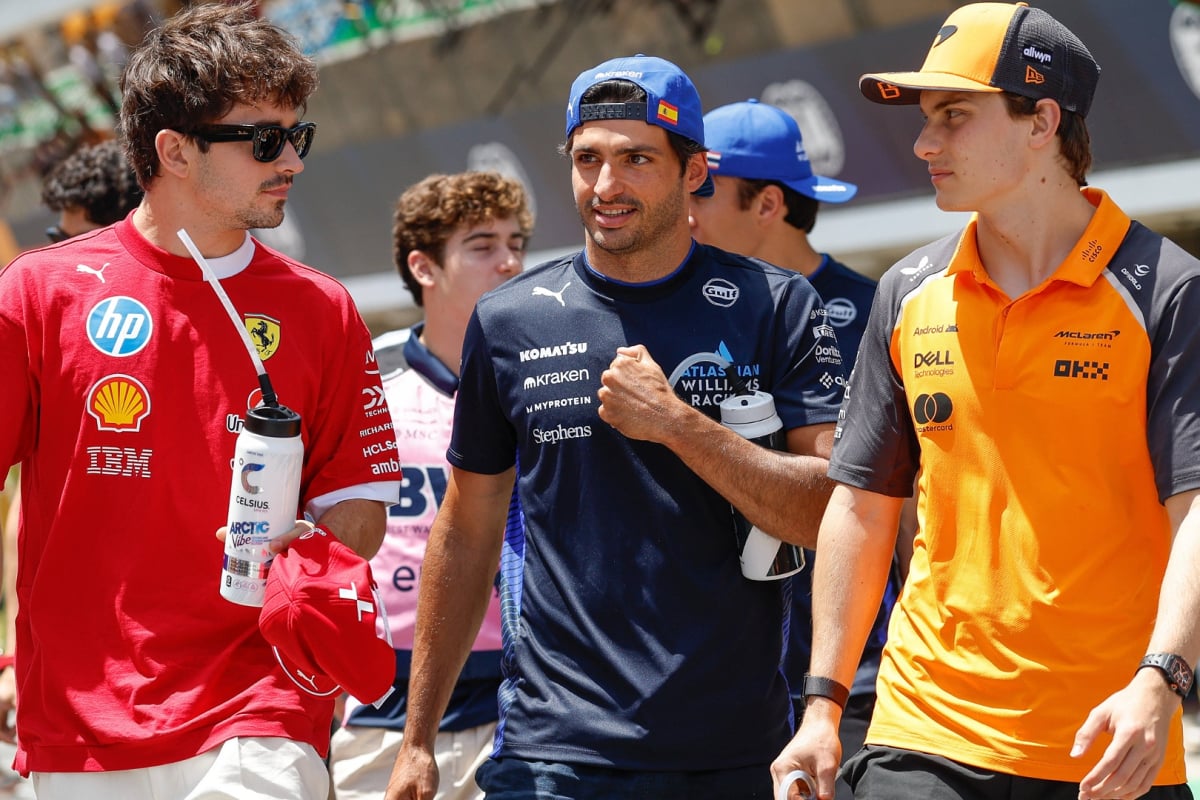 Leclerc, Sainz and Piastri walking in the F1 paddock looking concerned