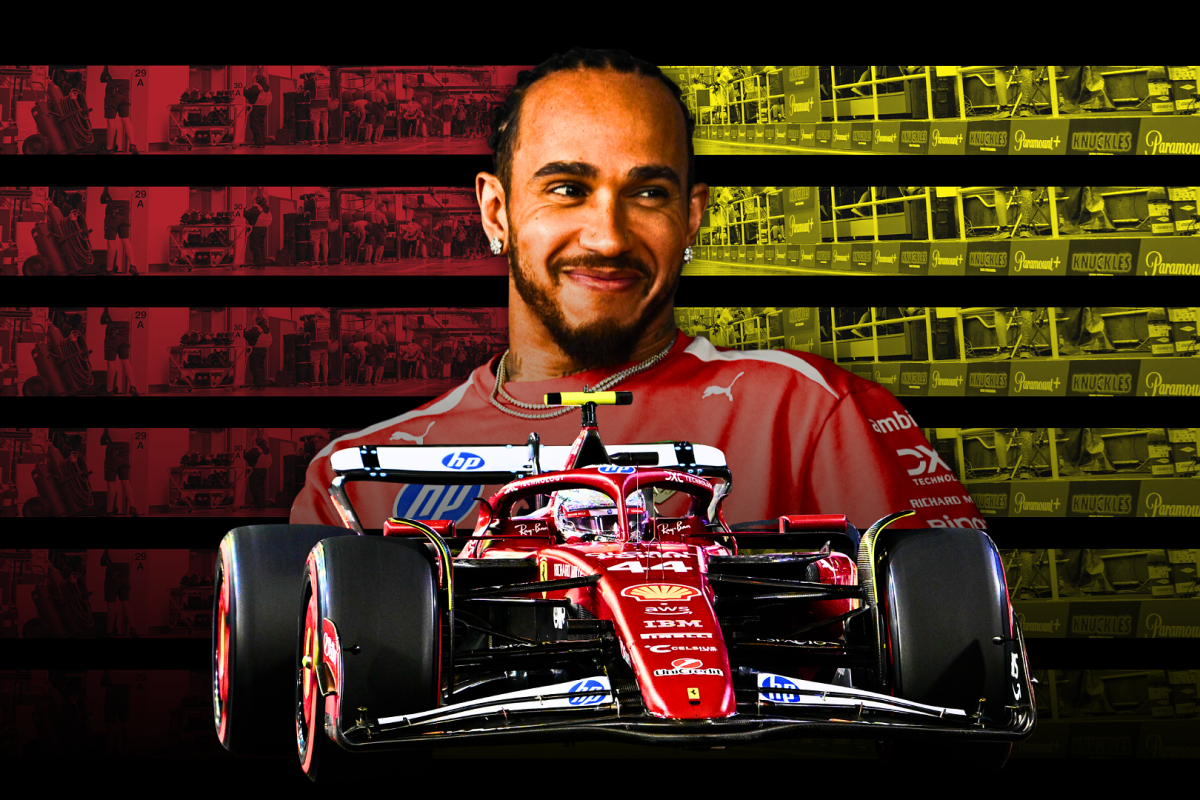 Hamilton smiling in front of a red, black and yellow background with his Ferrari F1 car in the foreground