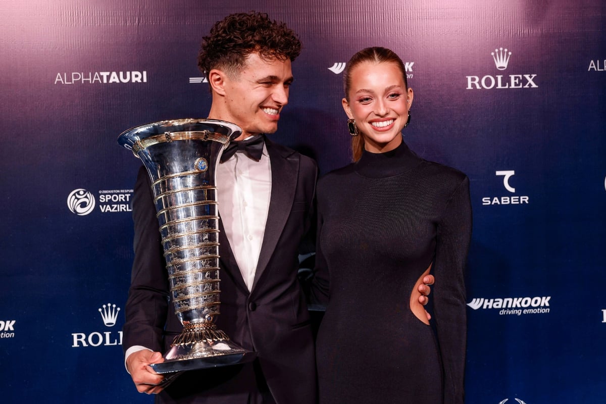 Lando Norris holding F1 drivers' trophy alongside Magui Corceiro at 2025 FIA prize ceremony