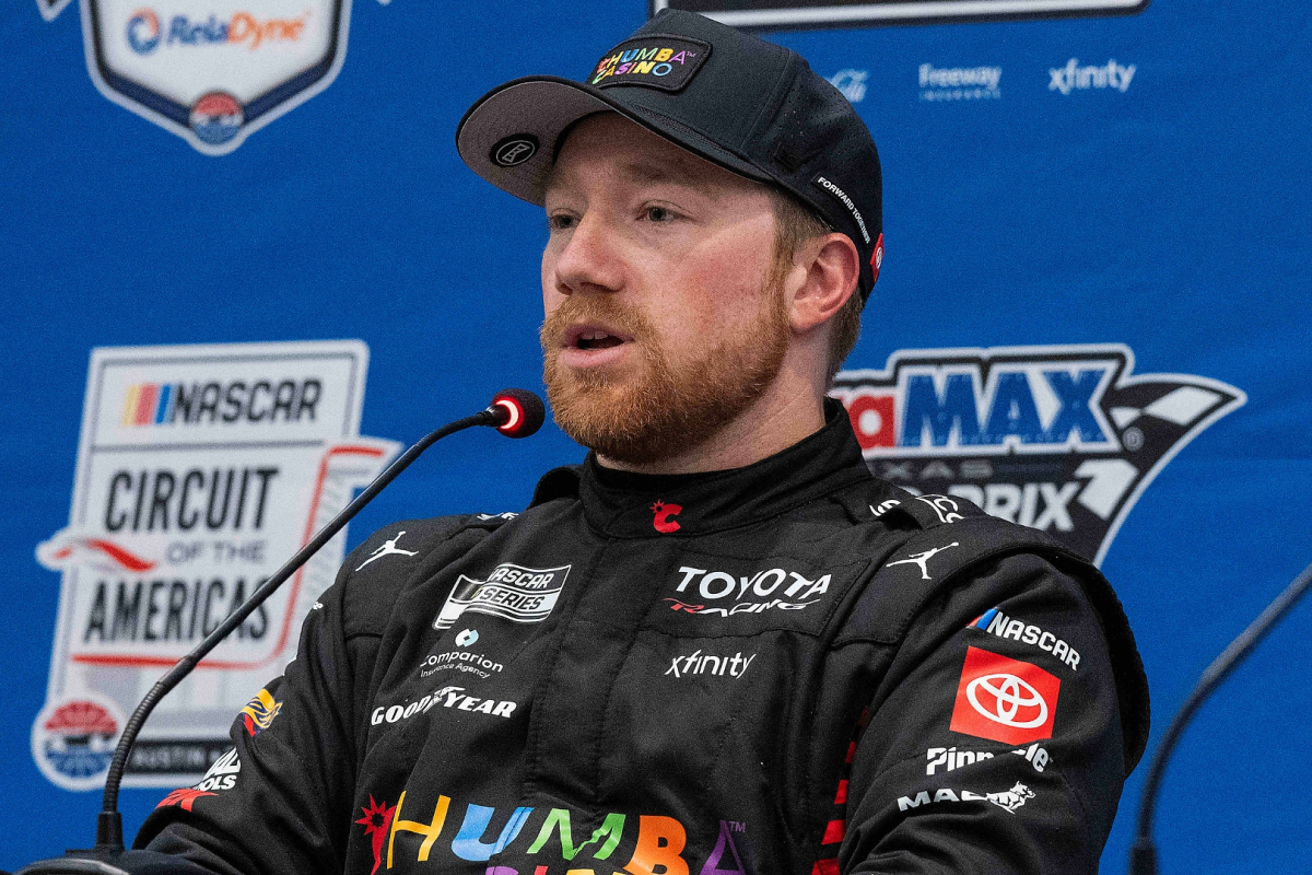 An image of 23XI Racing NASCAR driver Tyler Reddick speaking at a press conference