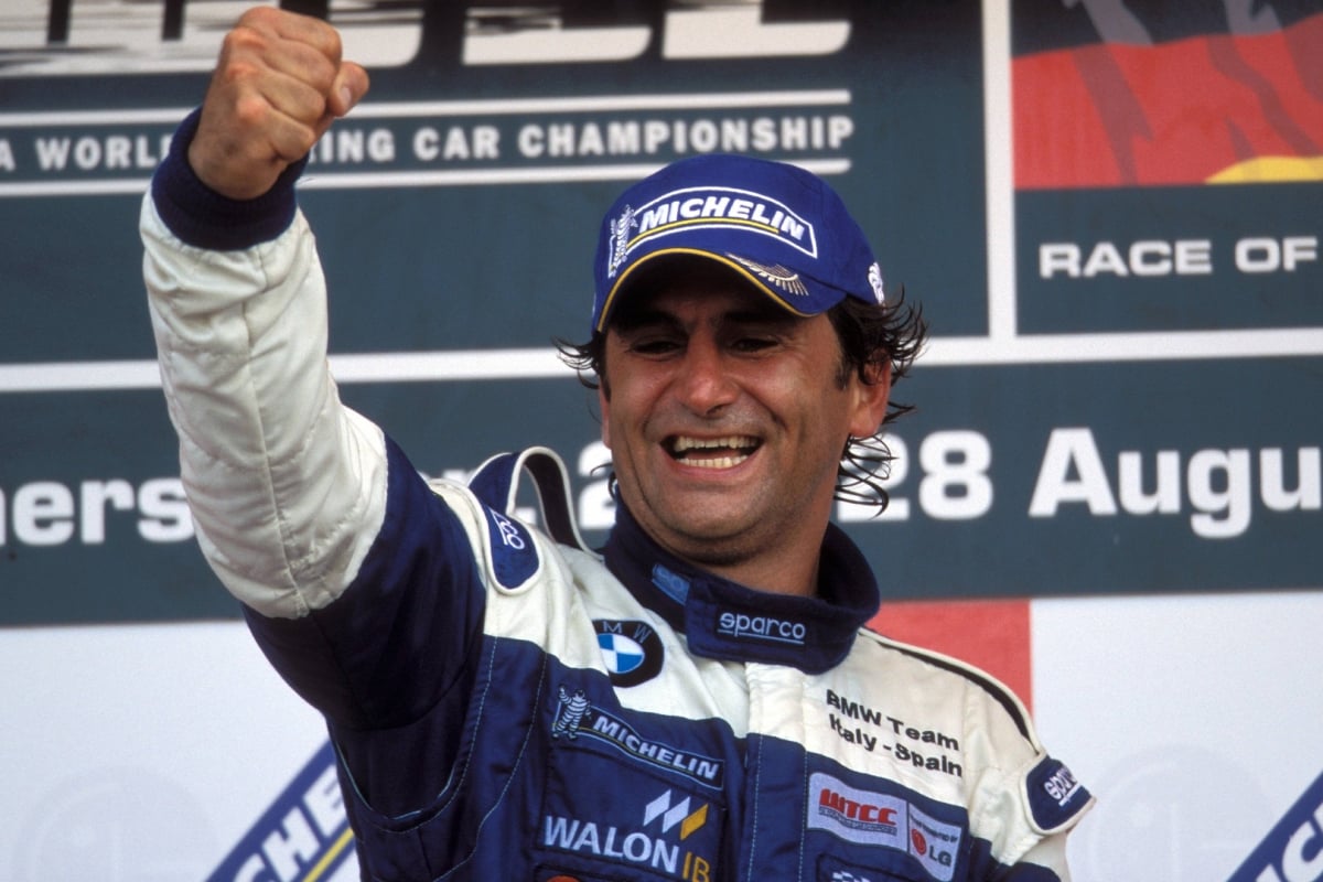 Alex Zanardi punches the air in celebration on the podium