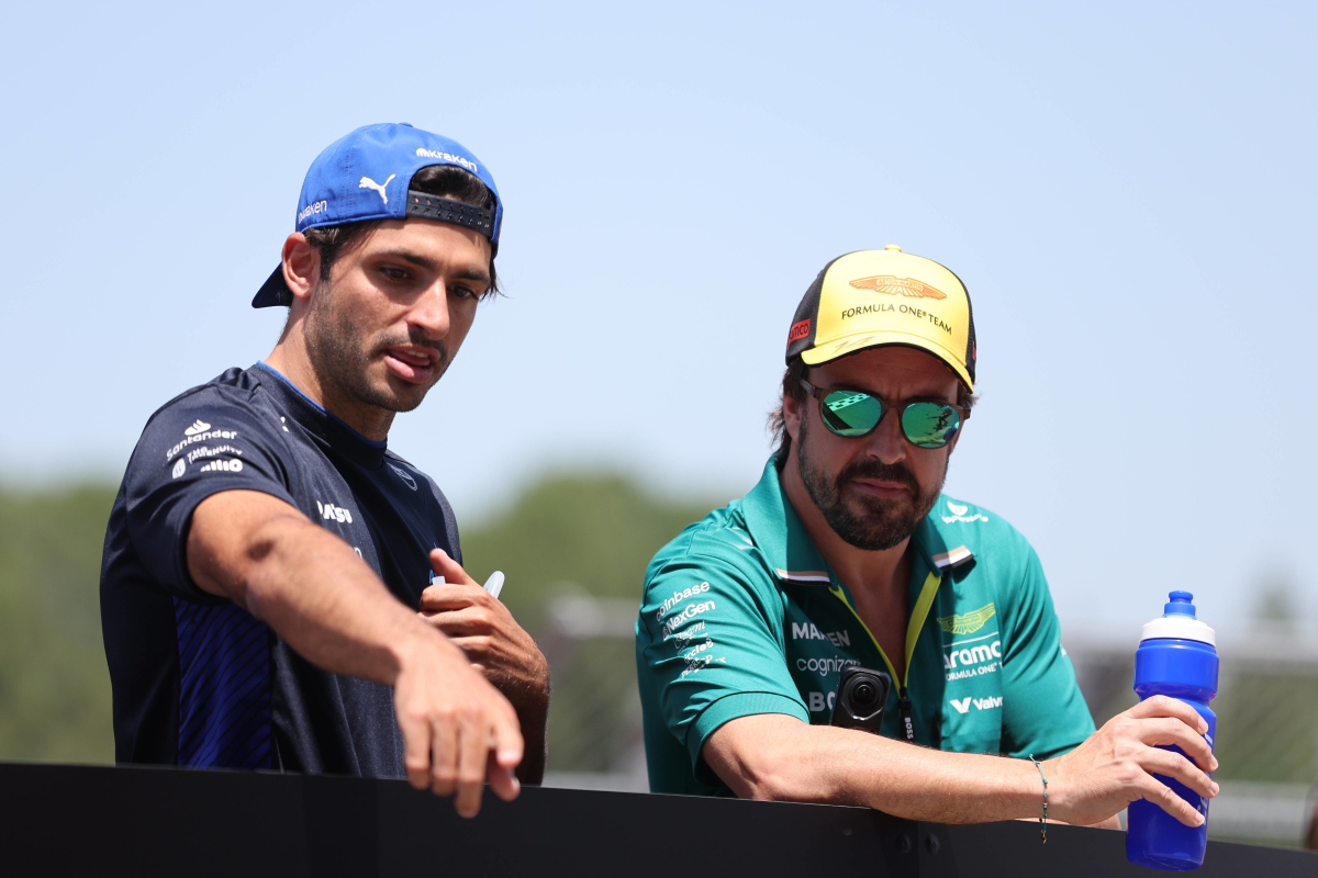 Carlos Sainz and Fernando Alonso pointing and waving at fans during the drivers' parade