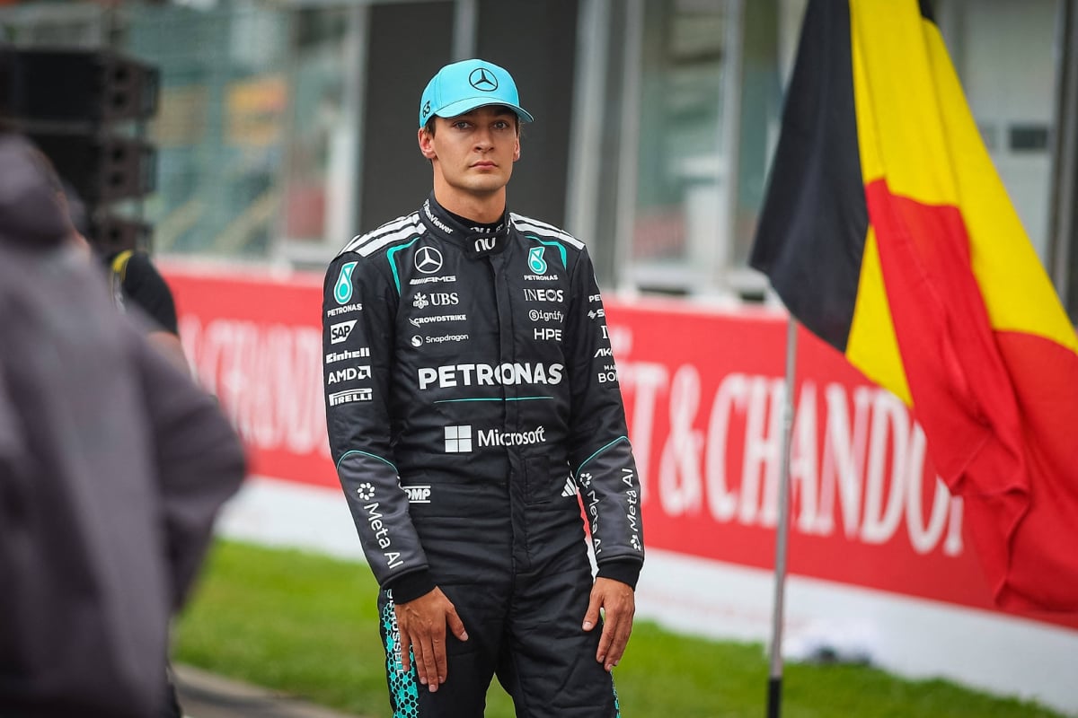 George Russell looks forlorn at the Belgian Grand Prix in front of the Belgian flag