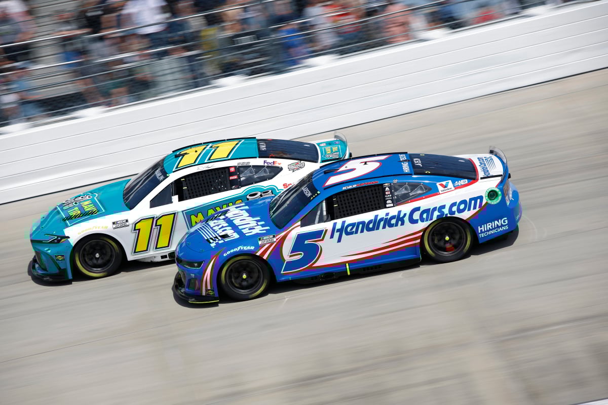 An image of Kyle Larson and Denny Hamlin racing in NASCAR at Dover Motor Speedway