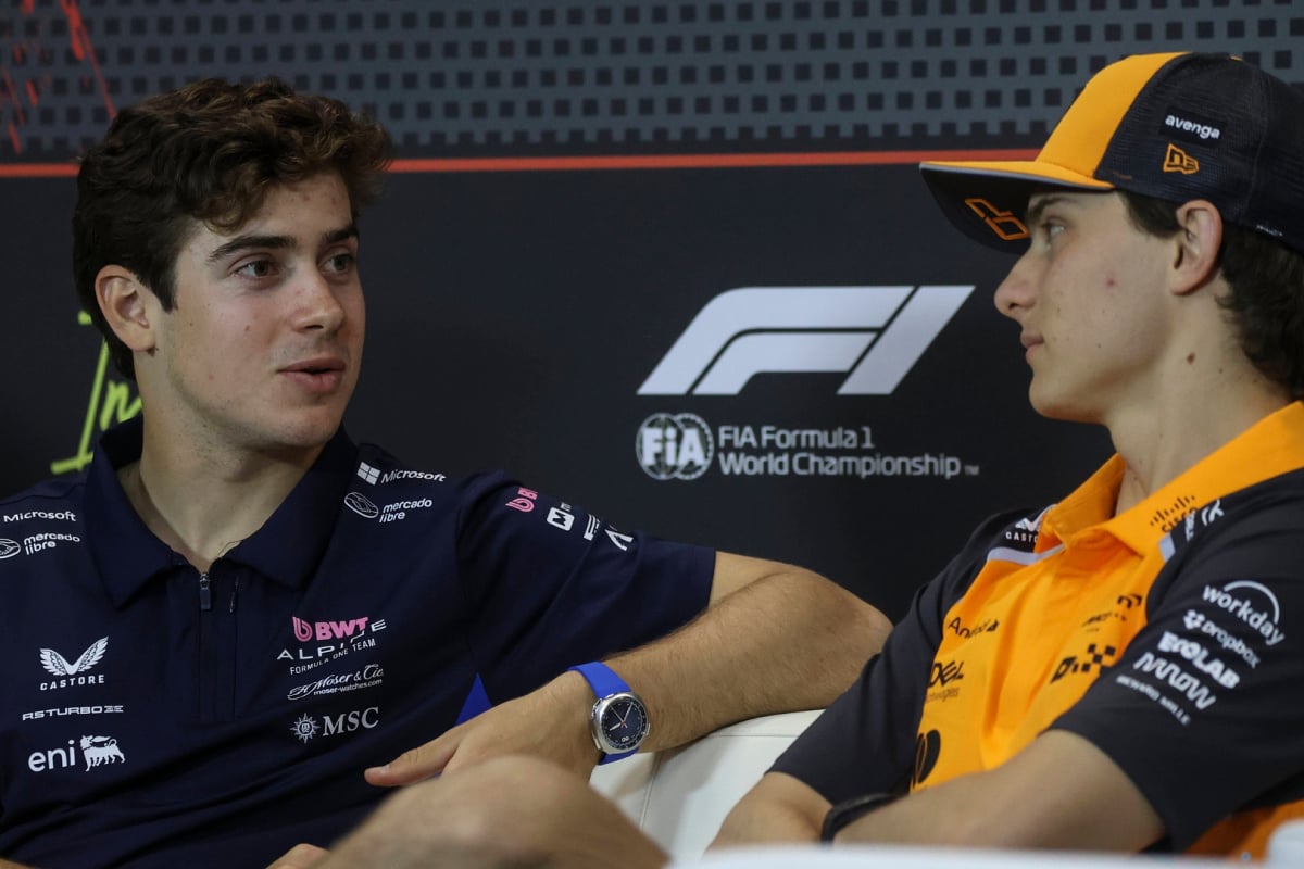 Colapinto and Piastri facing each other in conversation on the FIA press conference couch