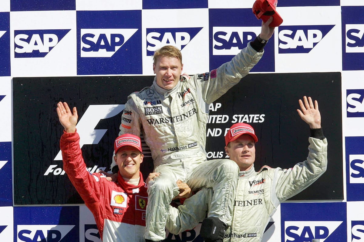 Mika Hakkinen celebrates winning the 2001 United States Grand Prix with Michal Schumacher and David Coulthard