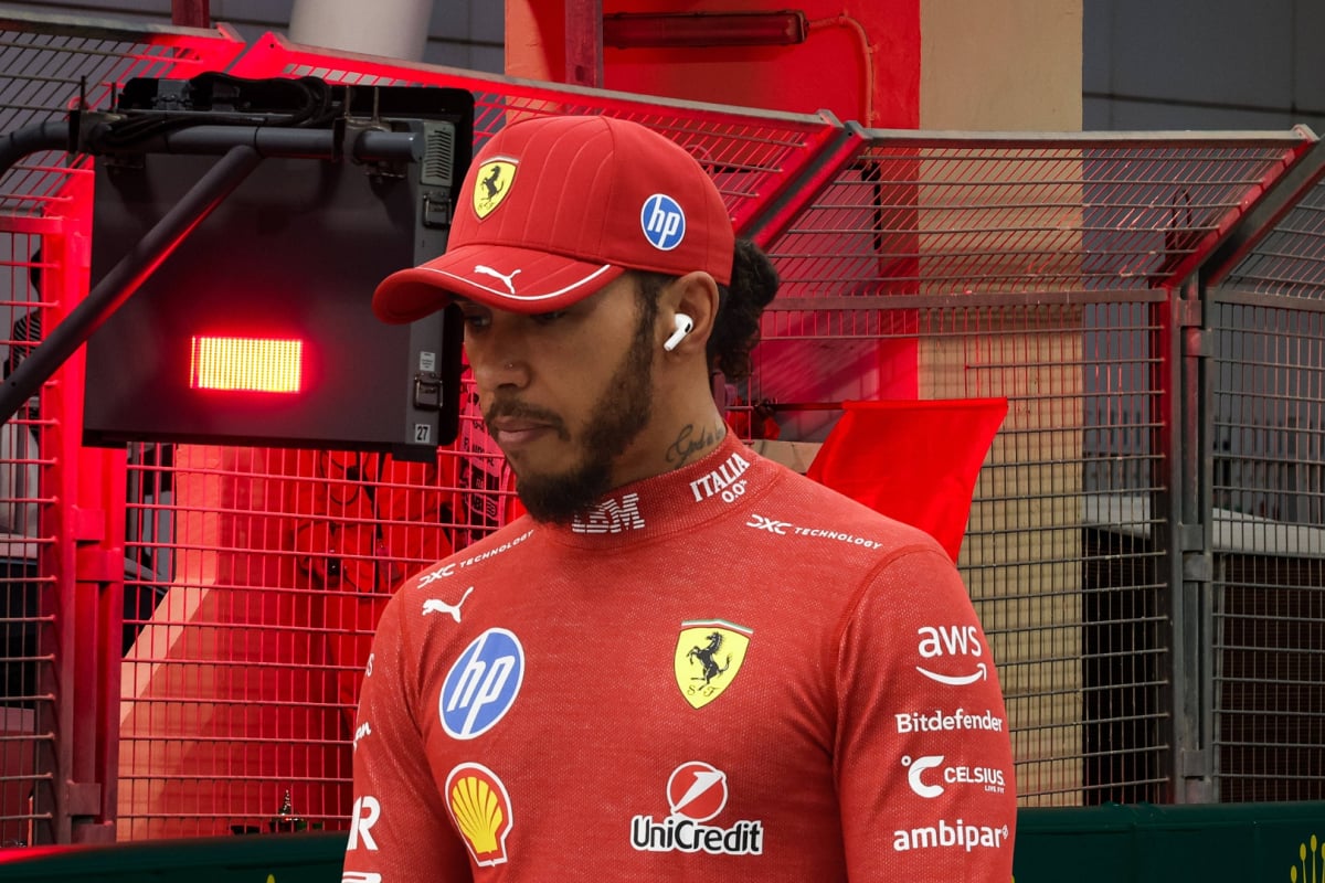 Lewis Hamilton looks sad in front of a red flag