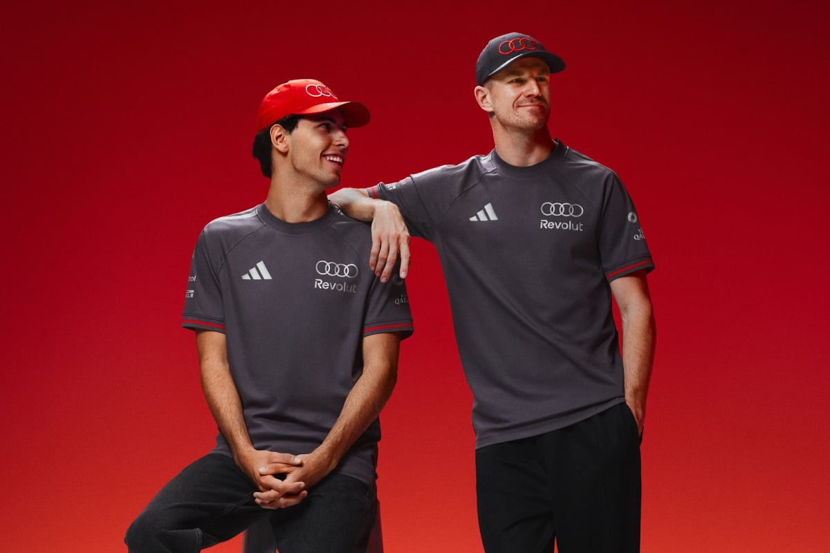 Credit: Audi. Bortoleto leaning on Hulkenberg, both smiling in new Audi and adidas F1 kit.