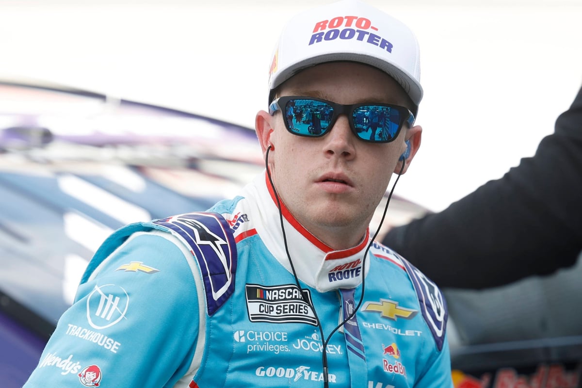 An image of Trackhouse Racing star Connor Zilisch sat on his car and staring into the distance
