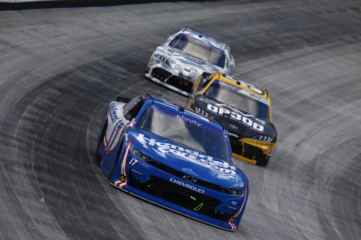 An image of three Xfinity Series NASCAR cars racing closely at Bristol Motor Speedway