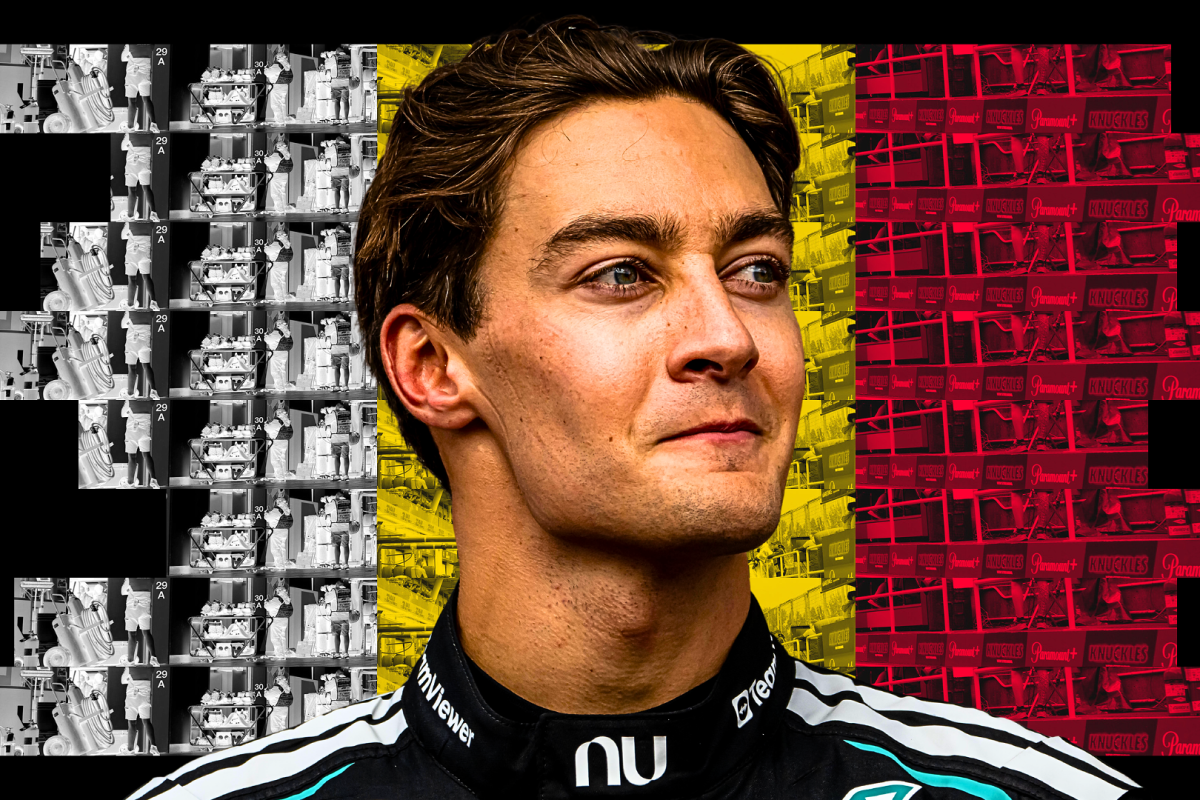 George Russell looks happy in front of the Belgian flag