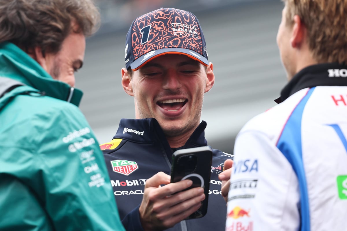 Max Verstappen laughing as he looks at his phone