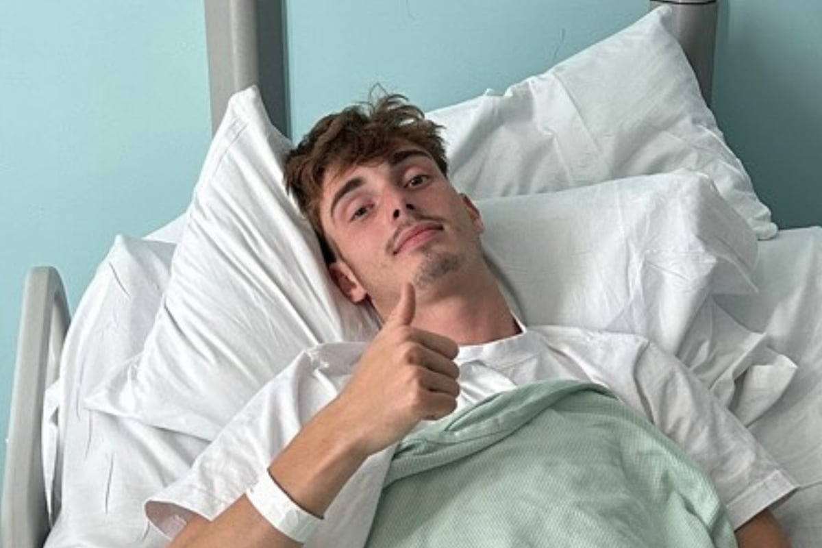 Will Macintyre gives a thumbs up from a hospital bed