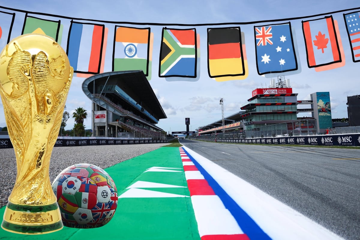 The FIFA world cup trophy and a ball sit on the tarmac at the Barcelona GP with a banner of flags above them