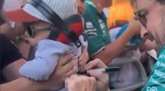 Fernando Alonso signeert over het hek hangende baby in Barcelona