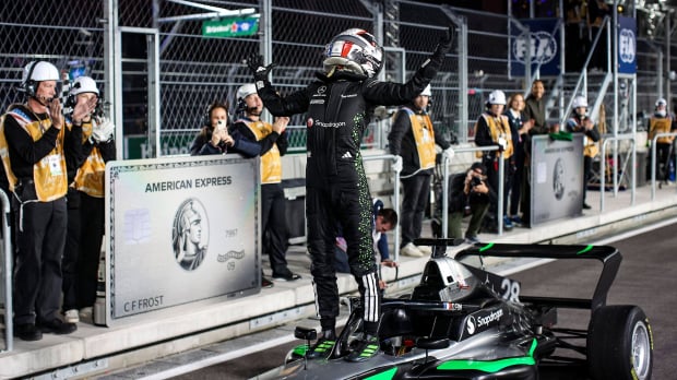 Doriane Pin stood on F1 Academy car with helmet and race suit on in Las Vegas GP pit lane after winning championship