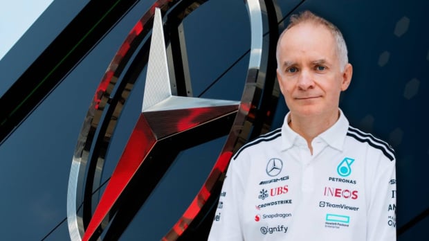 Silver Mercedes logo on side of a building with John Owen in Mercedes kit edited in front