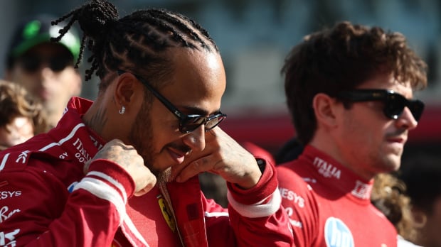 Hamilton smirking as Leclerc looks annoyed in the background on F1 grid