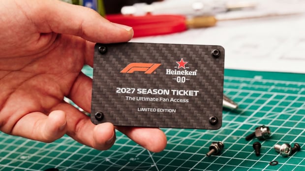 Hand holding black Heineken F1 2027 season ticket up close to camera — Photo: © Image Credit: Heineken x F1