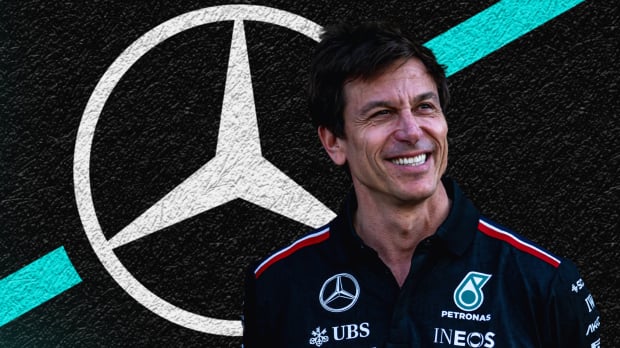 Toto Wolff smiling with a Mercedes logo black, white and turquoise background